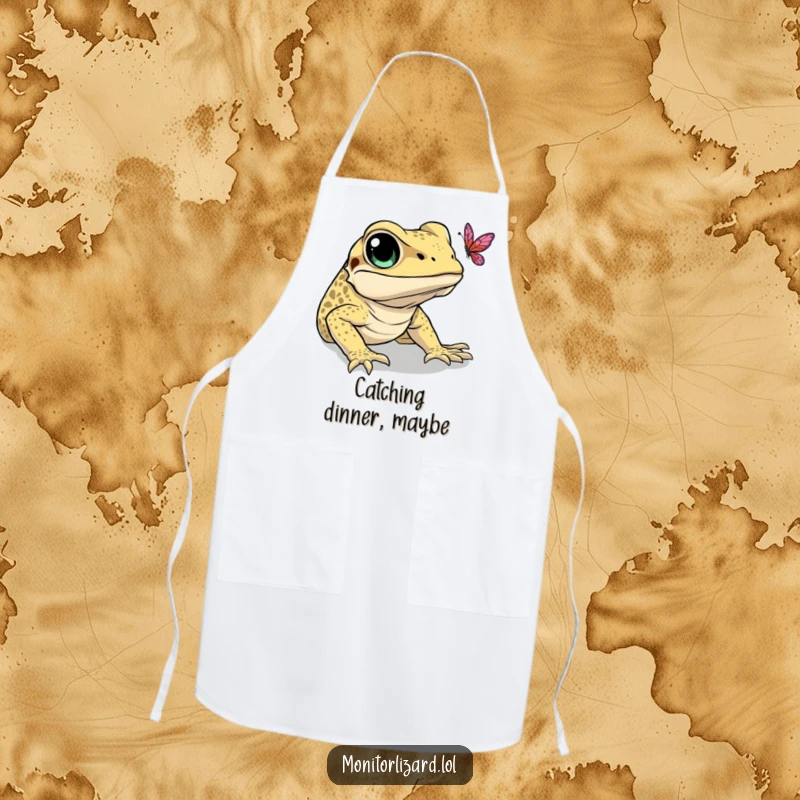 Funny apron showing a monitor lizard with wide eyes, comically attempting to catch a butterfly. Perfect for kitchen fun.