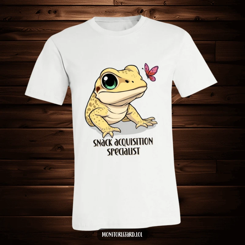 Funny t-shirt depicting a monitor lizard with bright eyes, comically attempting to catch a floating butterfly. A humorous nature scene.